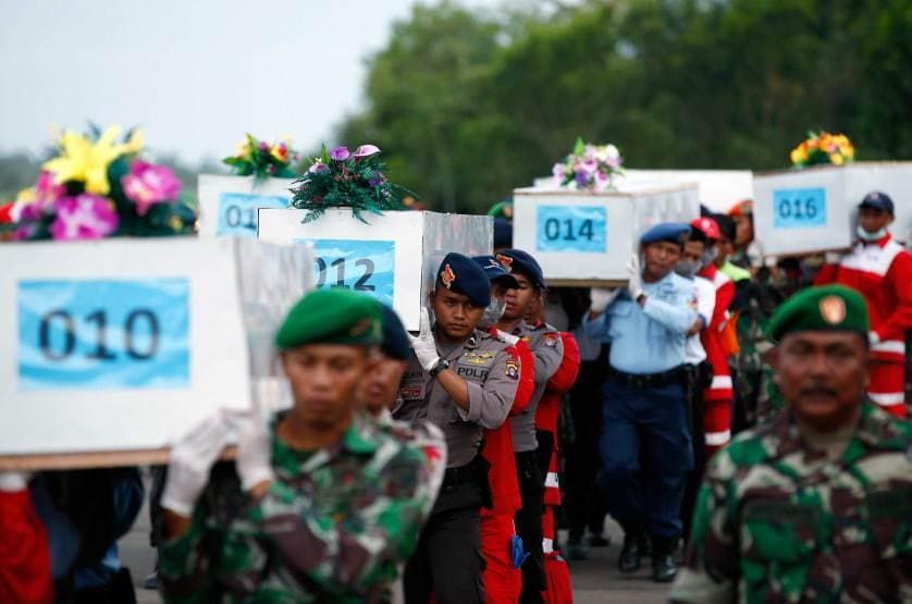 Caskets containing the remains of AirAsia QZ8501 passengers recovered from the sea are carried to a military transport plane at the airport in Pangkalan Bun